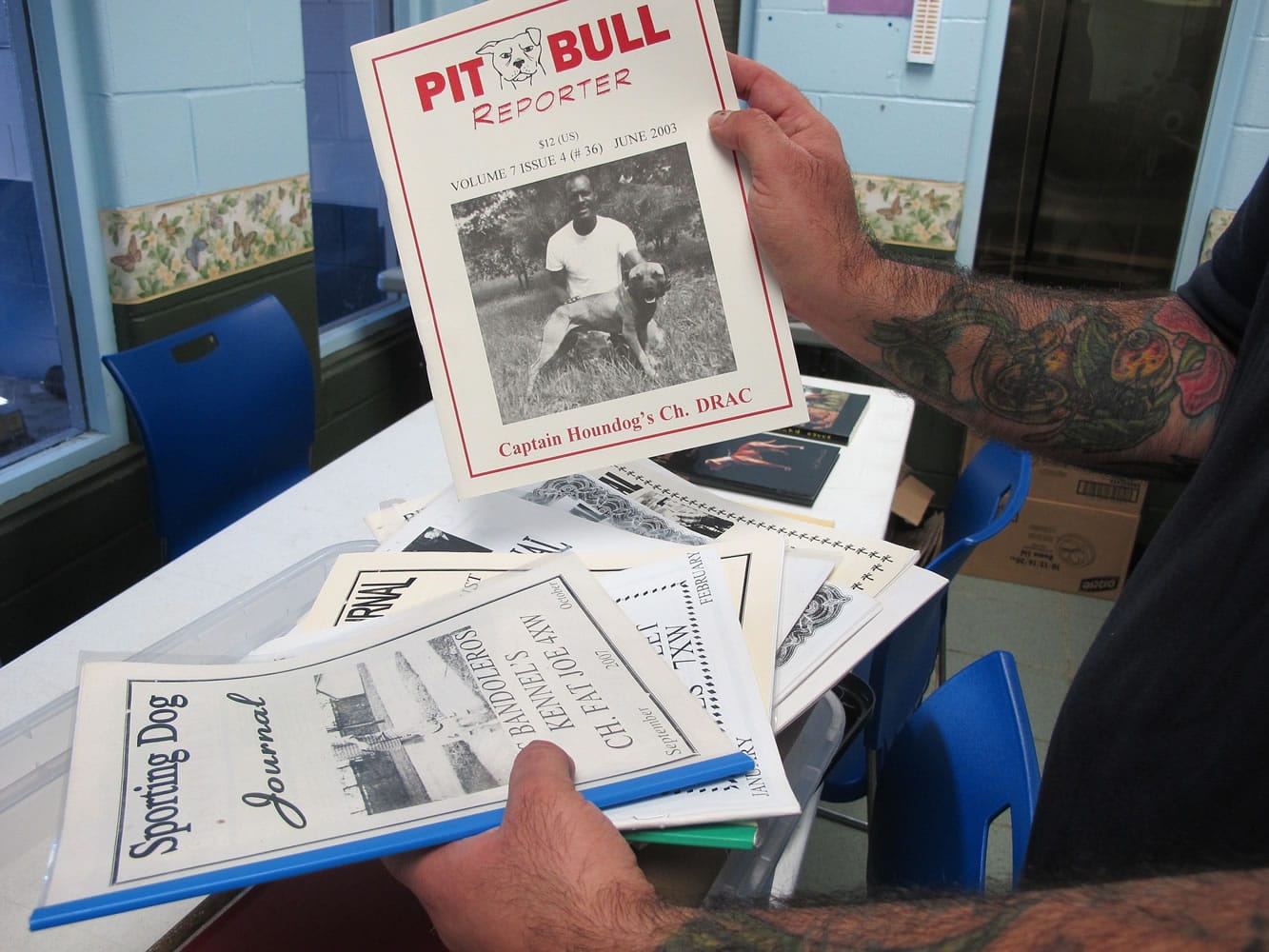 Chris Schindler of the Humane Society, holds underground magazines seized during raids on dog fighting groups. Police detectives and prosecutors around the U.S.