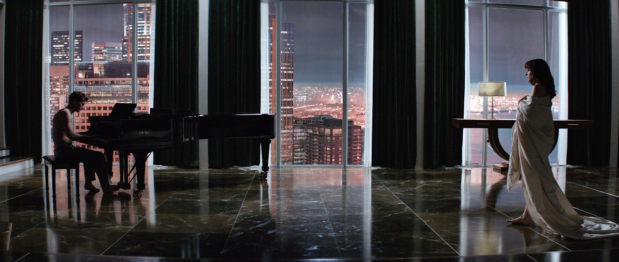 In this image released by Universal Pictures and Focus Features, Jamie Dornan, left, and Dakota Johnson appear in a scene from &quot;Fifty Shades of Grey.&quot; (AP Photo/Universal Pictures and Focus Features)