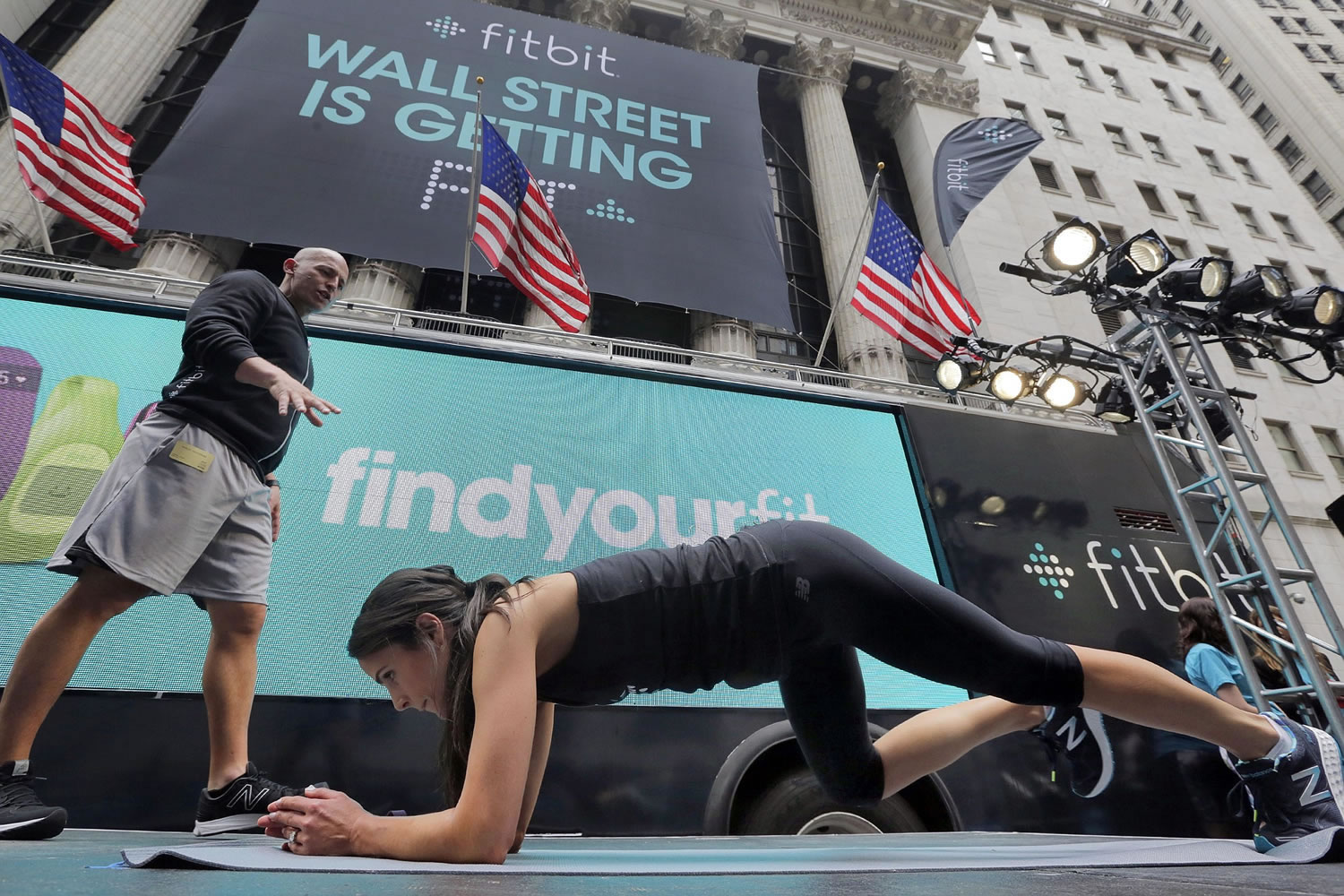 Fitness expert Harley Pasternak, left, and actress Jordana Brewster lead a workout for Fitbit on Thursday in front of the New York Stock Exchange in New York.