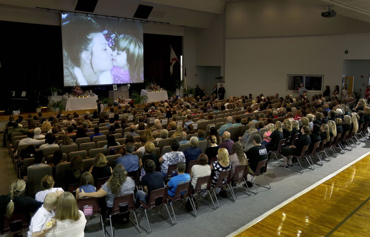 Images of Sarah Spirit and her children are displayed on a screen during a Memorial service at Bell High School in Bell, Fla., on Sept.