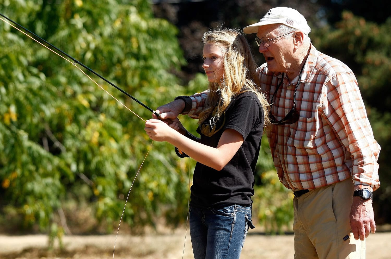 Frank Moore, of Idleyld Park, Ore., gives Brooklyn Wolfe, 11, of Camas Valley, Ore., some pointers on casting a fly rod Saturday at the North Umpqua Fly Tying Festival in Glide, Ore.