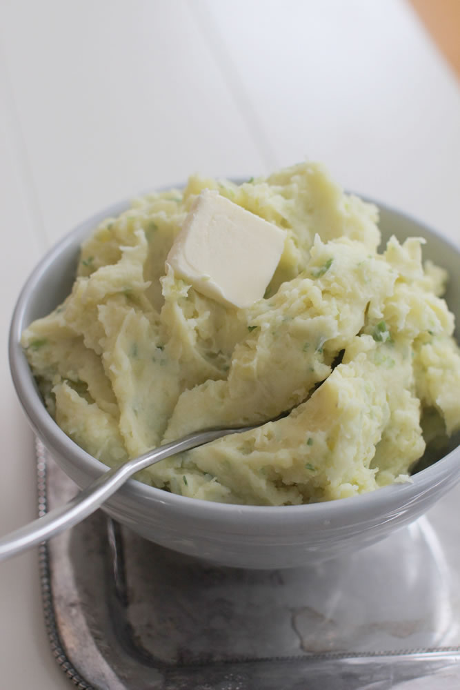 Mashed potatoes flecked with scallions and topped with butter