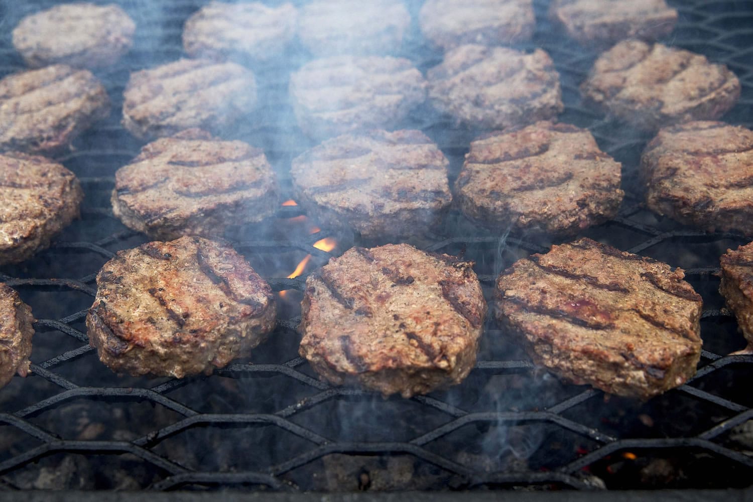 Smoke wafts up as hamburgers are cooked on a grill outside the White House in Washington.