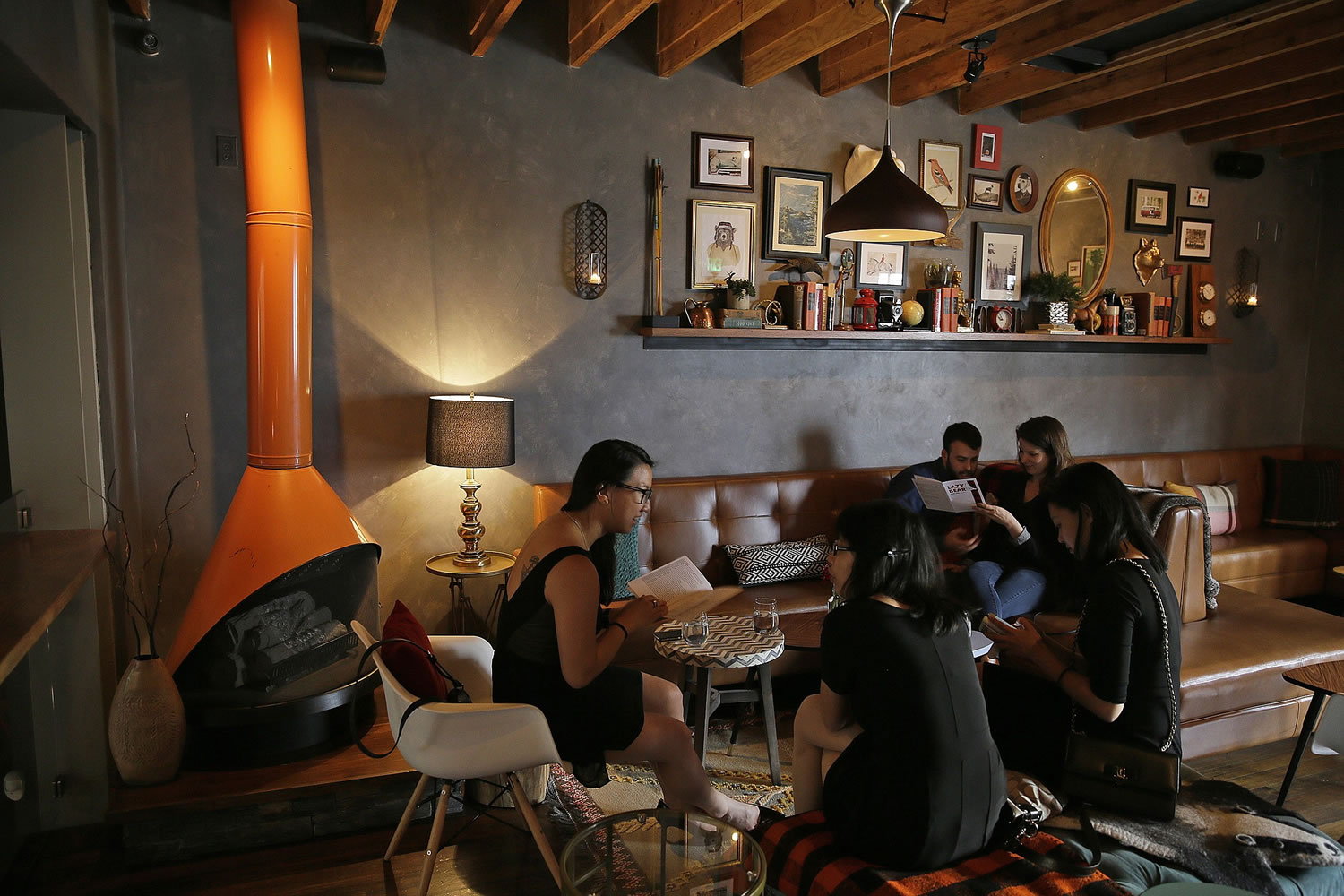Ticketed diners look over menus in an upstairs lounge at the Lazy Bear restaurant in San Francisco. Lazy Bear uses an increasingly popular ticketing system model for its &quot;reservations&quot; that asks diners to pay up front for their meals much the way theater patrons pay for their seats.