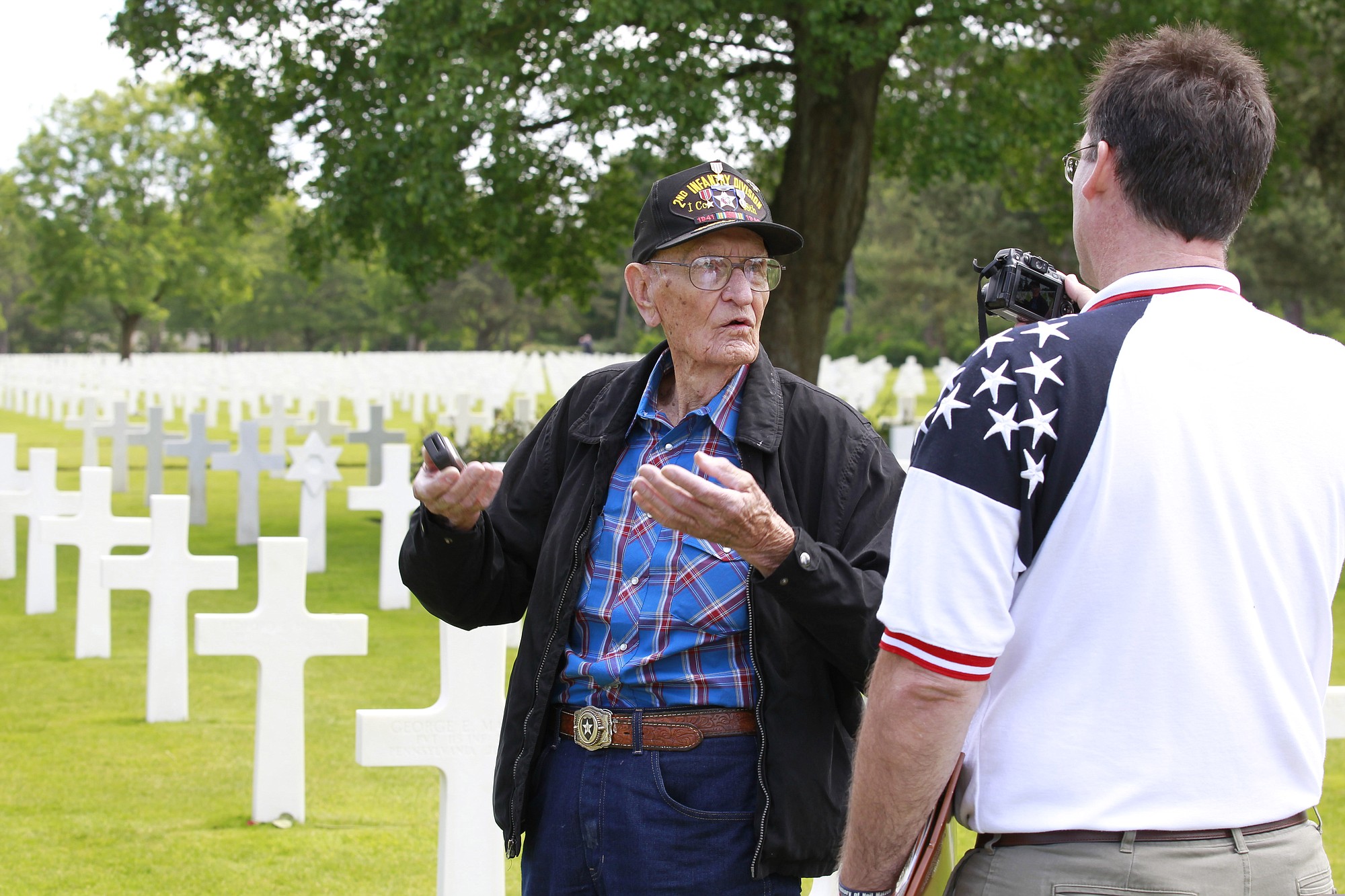 U.S. WW II veteran Thomas N. Oglesby, 95, from Redding, Calif., who belonged to the second infantry division called Indian Head, when he landed on June 7 in Saint Laurent sur Mer, talks with his grandson Mark, a history teacher from Dallas, Texas, at the Colleville American military cemetery, in Colleville sur Mer, western France, Saturday, on the 71st anniversary of the D-Day landing. D-Day marked the start of a Europe invasion, as many thousands of Allied troops began landing on the beaches of Normandy in northern France in 1944 at the start of a major offensive against the Nazi German forces, an offensive which cost the lives of many thousands. Thomas N.