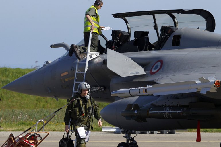 French Air Force pilot of a Rafale jet fighter seen in background comes back from a mission to Libya, at Solenzara 126 Air Base, Corsica island, Mediterranean Sea, Thursday, March 24, 2011.