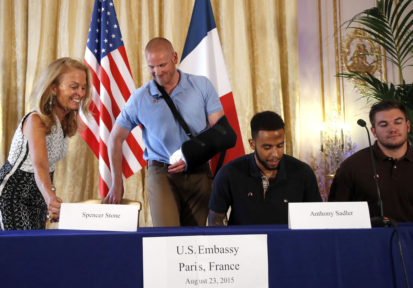 Anthony Sadler, a senior at Sacramento University in California, second right, U.S. National Guardsman from Roseburg, Ore., Alek Skarlatos, right, U.S. Airman Spencer Stone, second from left, and U.S. Ambassador to France Jane D. Hartley take their seats before a press conference held Sunday at the U.S.