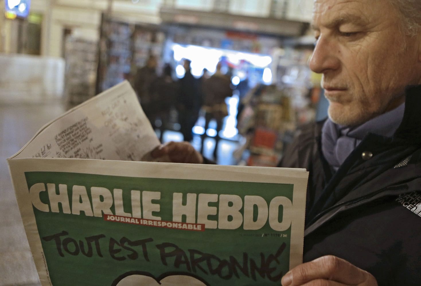 File - In this Wednesday, Jan. 14, 2015 file photo, Jean Paul Bierlein reads the latest issue of Charlie Hebdo outside a newsstand in Nice, southeastern France. When cartoonists at a French publication that had poked fun at the Prophet Muhammad were shot dead, millions around the world felt it as an attack on freedom of speech. Since the rampage, French authorities have arrested dozens of people _ including a comedian _ for appearing to praise the terrorists or encourage more attacks.
