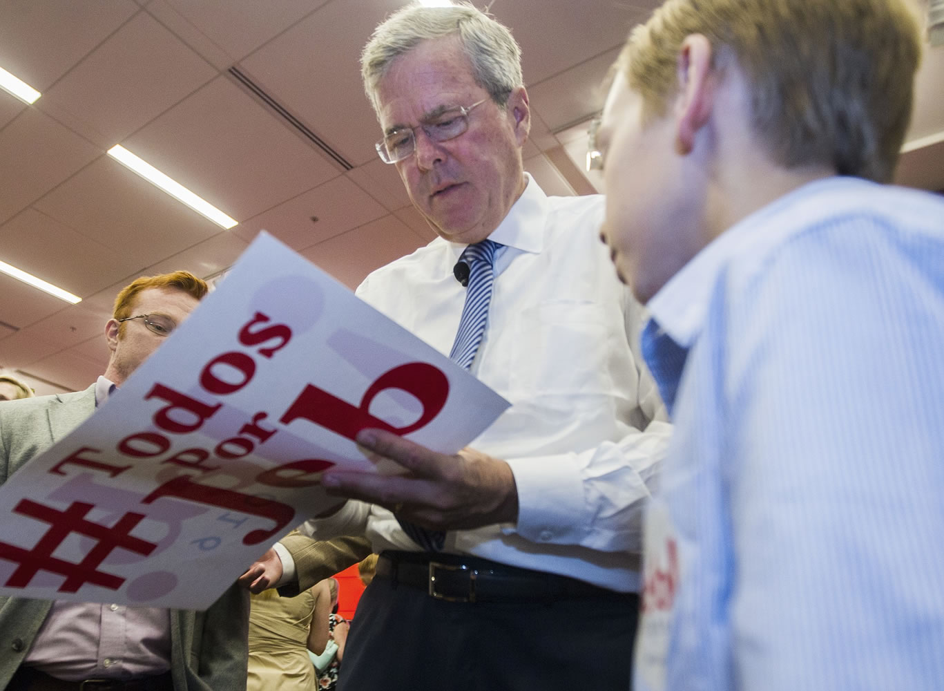 Republican presidential candidate, former Florida Gov. Jeb Bush, autographs campaign literature for a young supporter after speaking at the Florida State University Conference Center in Tallahassee, Fla., Monday, July 20, 2015.