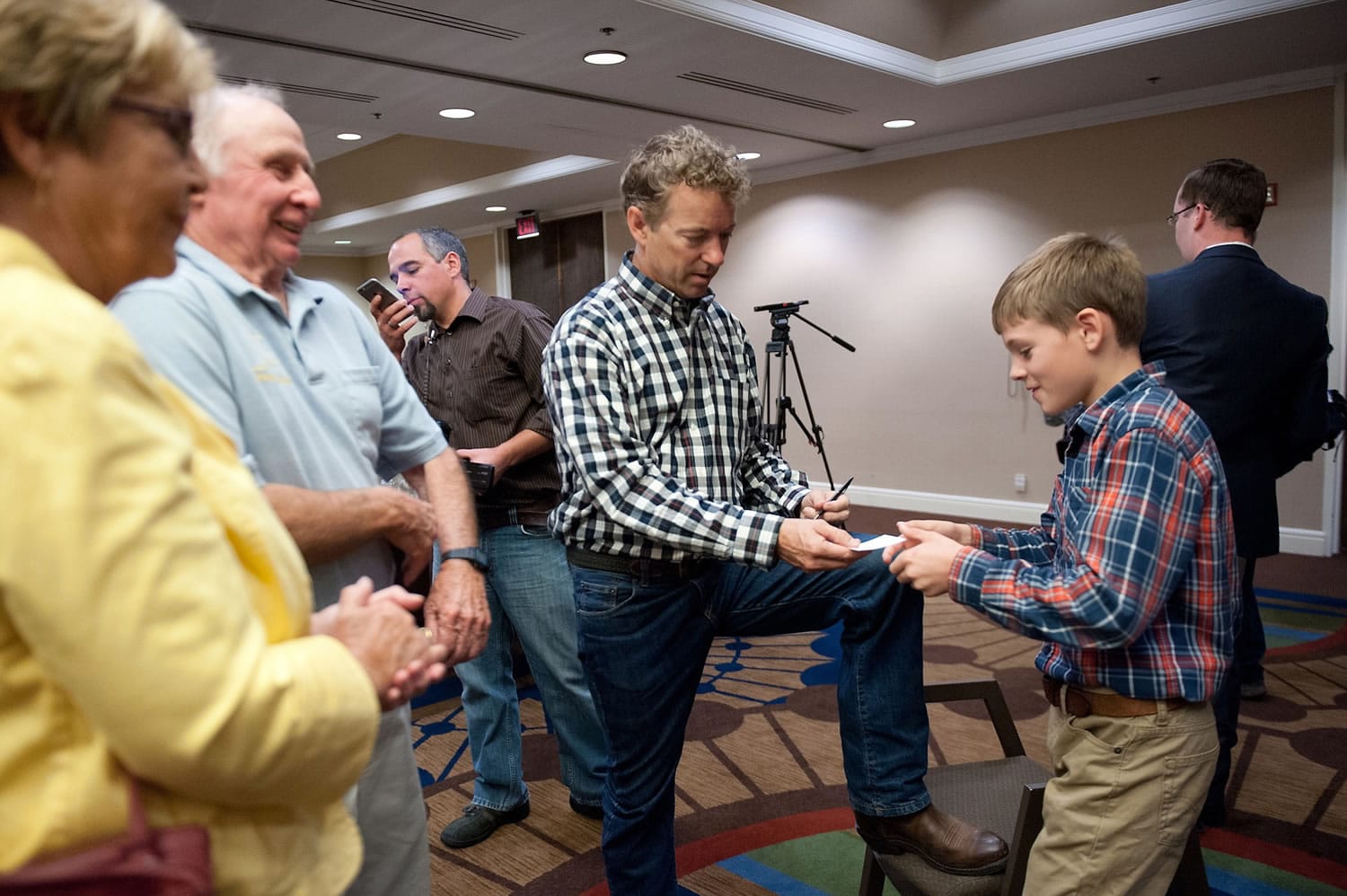 Republican presidential candidate Rand Paul, center, hands an autographed card to a young supporter at a campaign rally in Anchorage, Alaska, on Tuesday. At left are supporters Sally and Chuck Heath of Wasilla, Alaska.