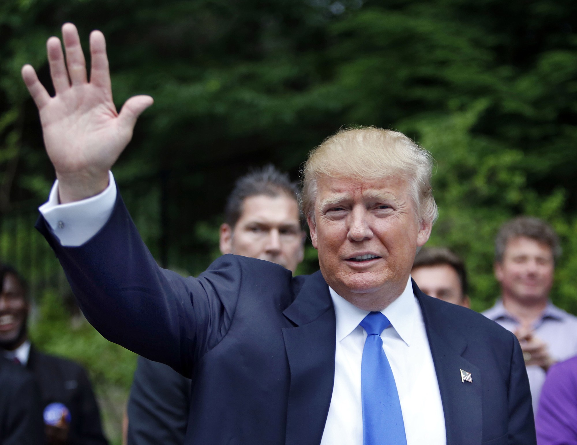 Republican presidential candidate Donald Trump waves as he arrives at a house party in Bedford, N.H.
