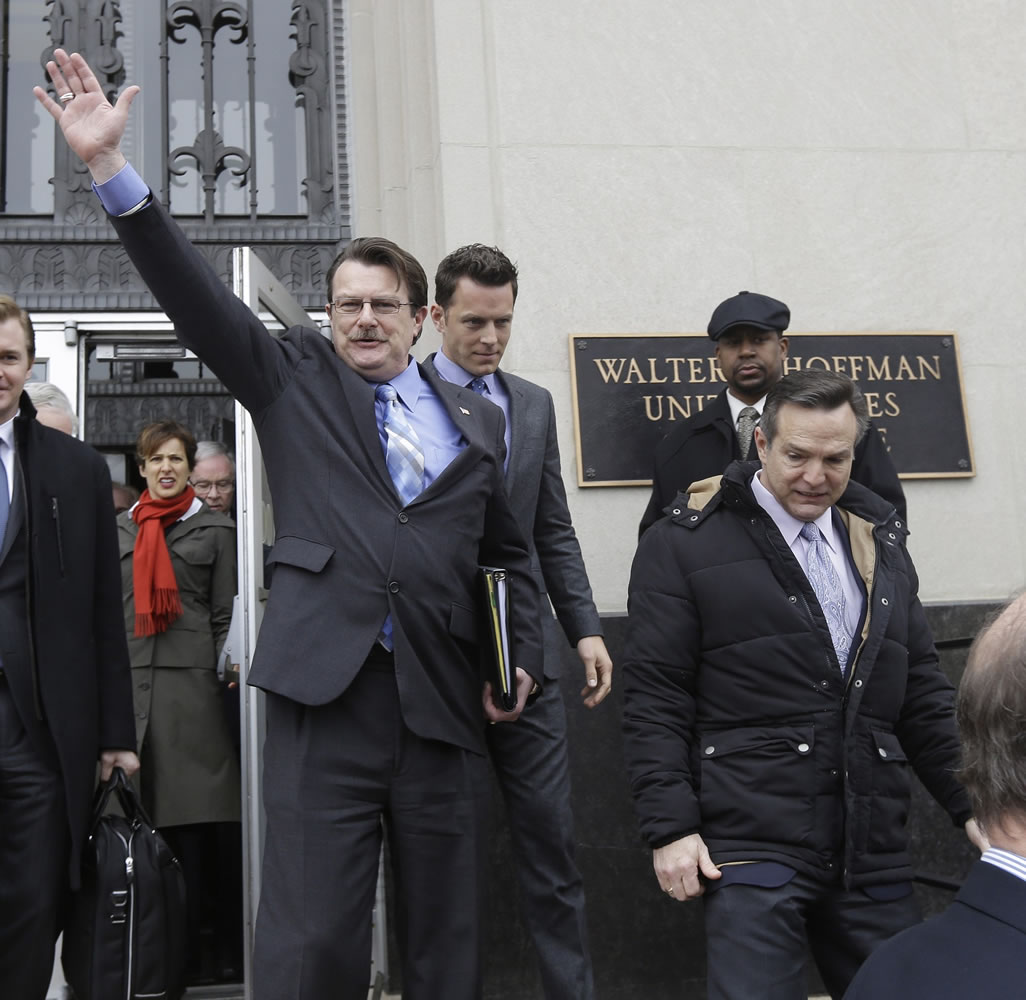 Tony London, a plaintiff in the Bostic v. Rainey case, waves to the crowd as he and his partner, Tim Bostic, right, leave Federal Court on Feb.