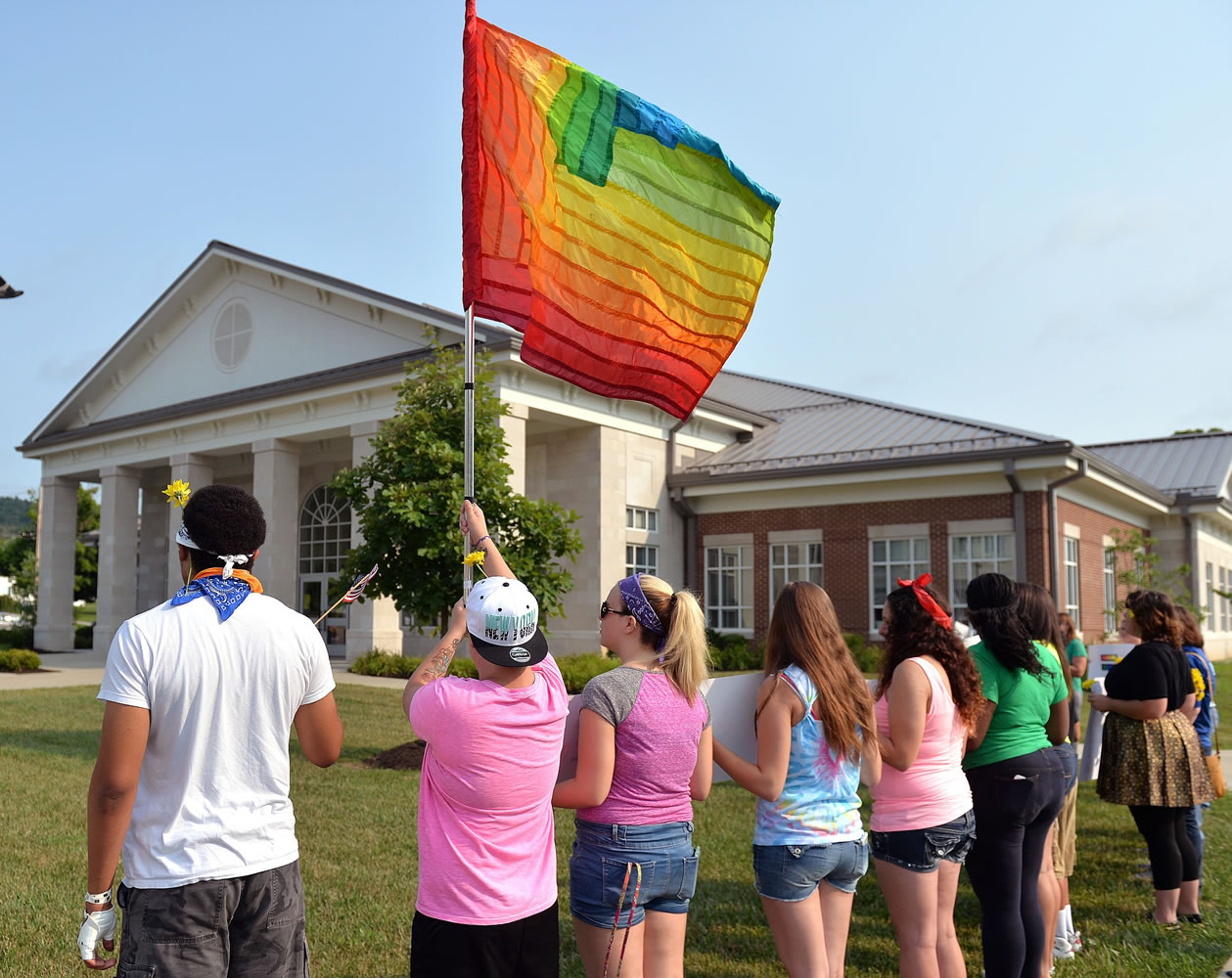 Protesters wave a rainbow flag Tuesday on the front lawn of the Rowan County Judicial Center in Morehead, Ky.