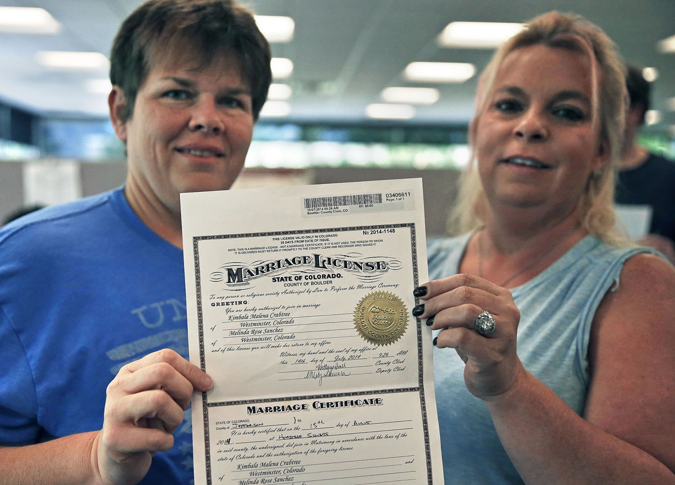 Same-sex couple Melinda Sanchez, left, and Kim Crabtree display their  marriage license Tuesday inside the offices of the Boulder County Clerk and Recorder in Boulder, Colo.