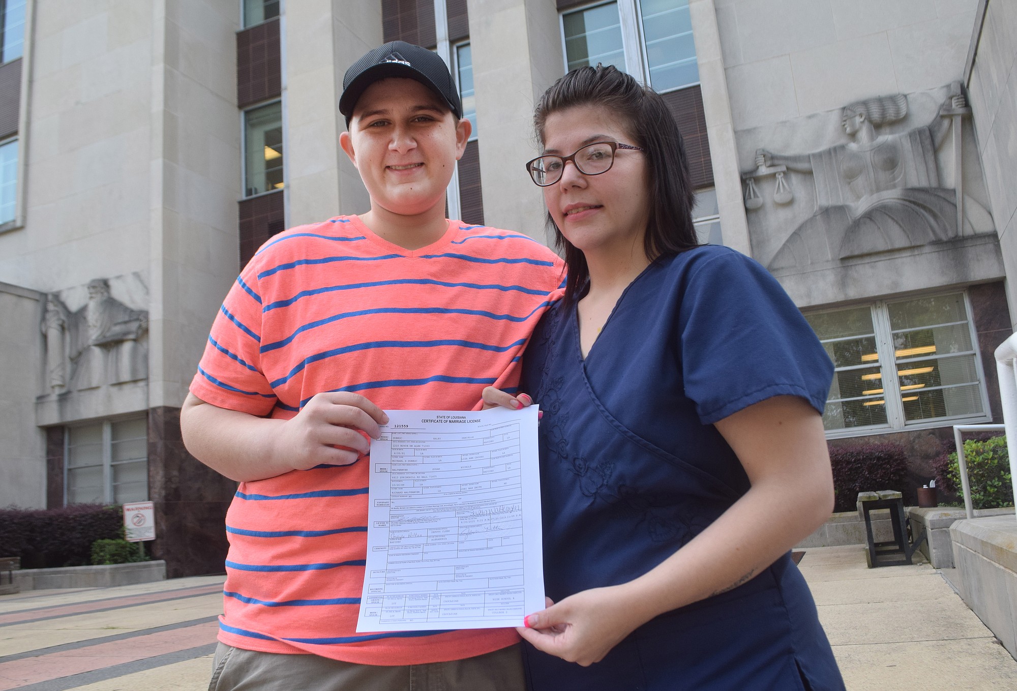 Haley Dubroc, left, and Susan Waltermyer hold their marriage license outside the Rapides Parish Courthouse in Alexandria, La., on Tuesday.