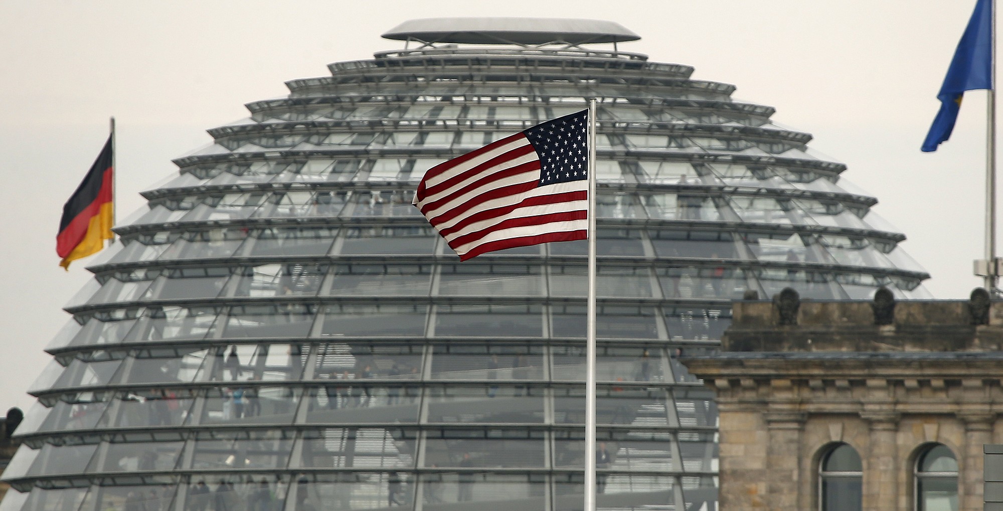 The US  flag flies  on top of the US embassy in front  of the  Reichstag building  that houses the German  Parliament, Bundestag, in Berlin.