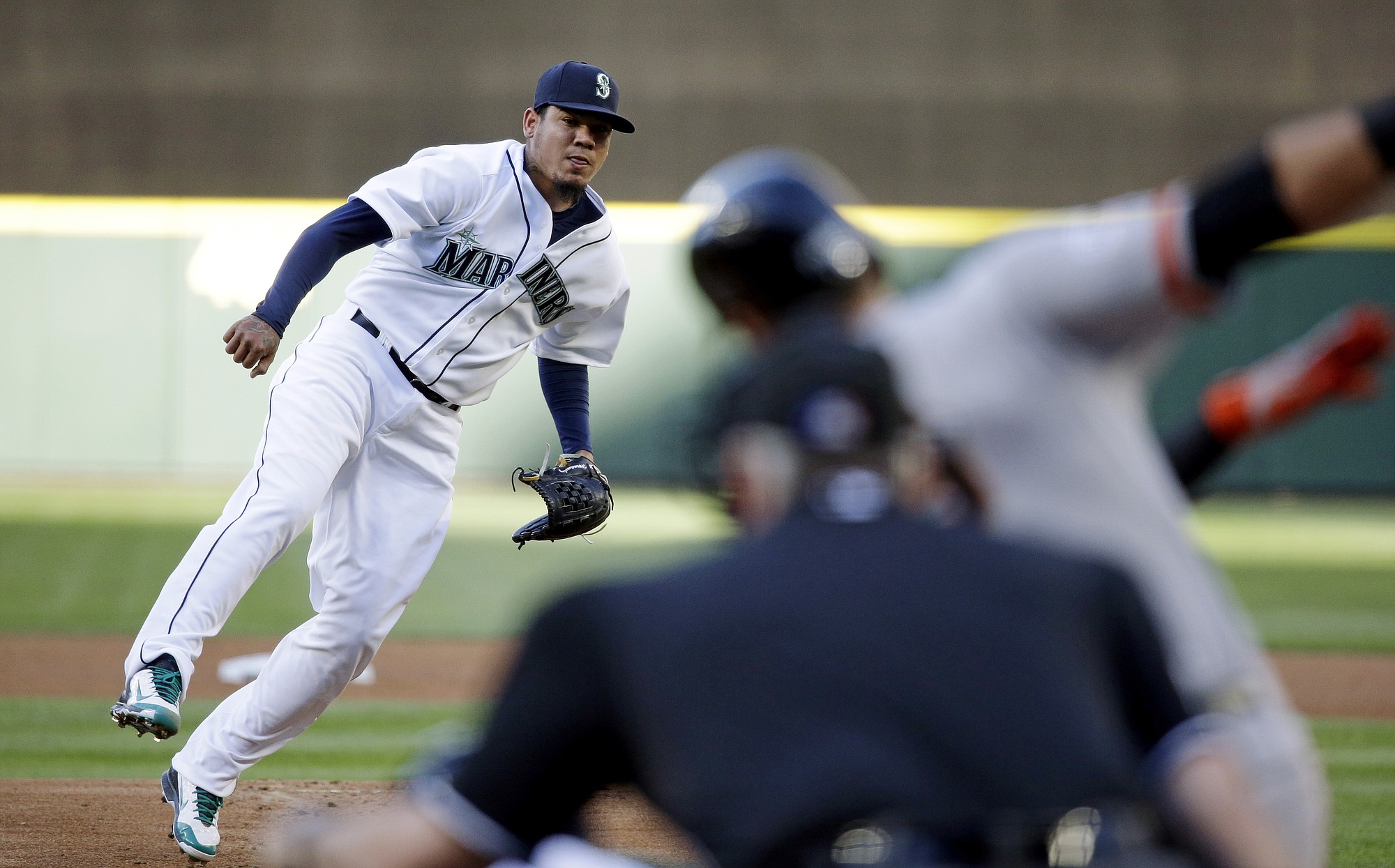 Seattle Mariners starting pitcher Felix Hernandez, left, watches as San Francisco Giants' Joe Panik swings and misses to strike out during the first inning Wednesday, June 17, 2015, in Seattle.