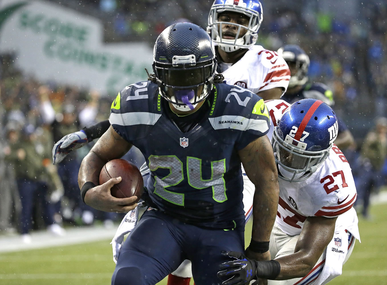 Seattle Seahawks running back Marshawn Lynch (24) scores his fourth touchdown against the New York Giants, as Giants' Stevie Brown (27) attempts the tackle in the second half, Sunday, Nov.