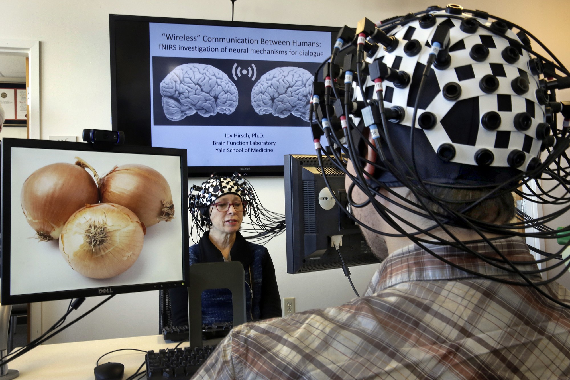 Shaw Bronner, left, and Shaul Yahil, two researchers at the Yale Brain Function Lab, describe images on their computer screens to each other while their brain activity is mapped Friday during a demonstration of the technology in New Haven, Conn.
