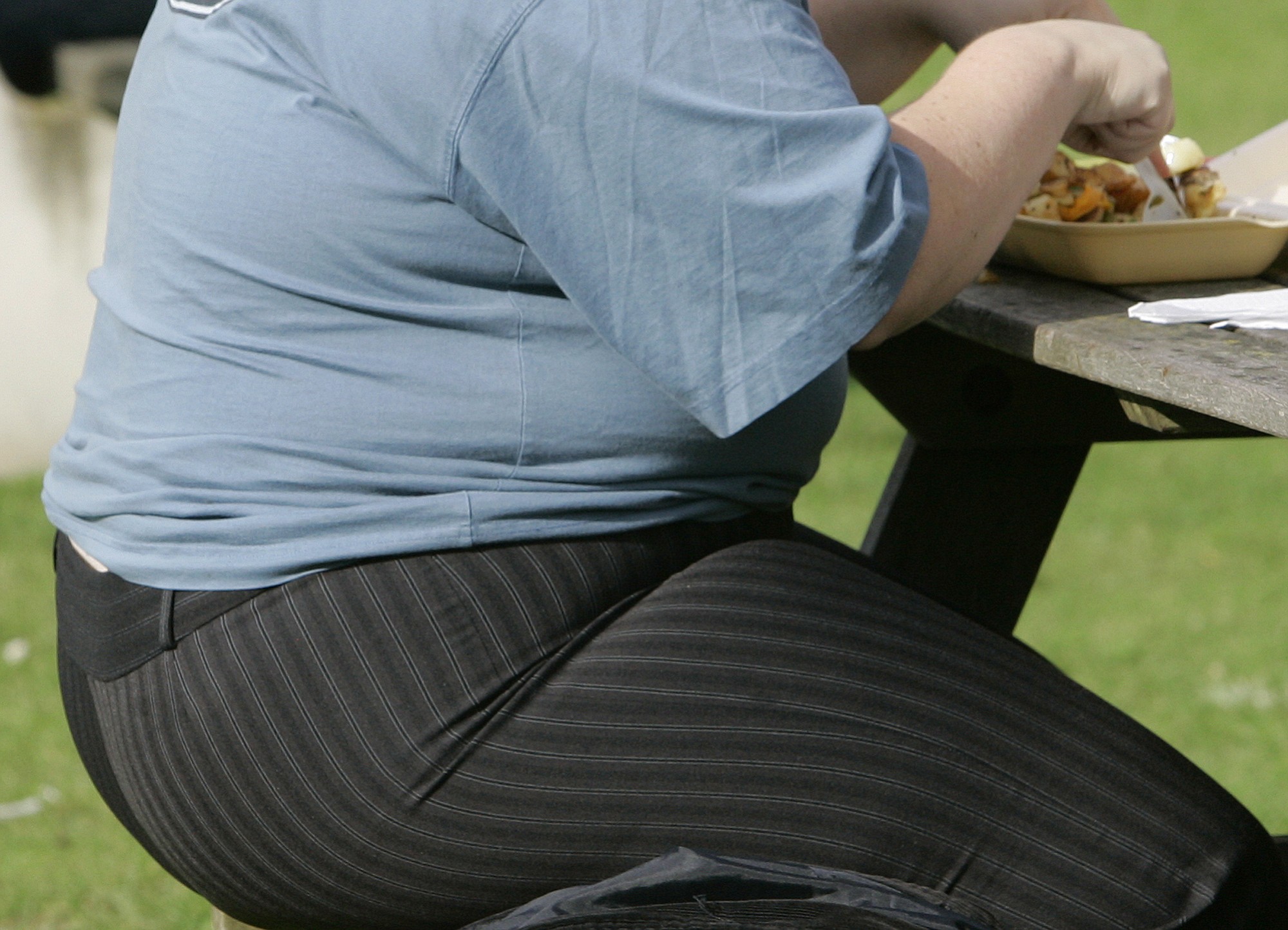 An overweight person eats in London. A new report by the McKinsey Global Institute released Thursday says that the global cost of obesity has risen to $2 trillion annually -- nearly as much as smoking or the combined impact of armed violence, war and terrorism. The report released Thursday focused on the economics of obesity, putting it among the top three social programs generated by human beings. It puts its impact at 2.8 percent of global gross domestic product.