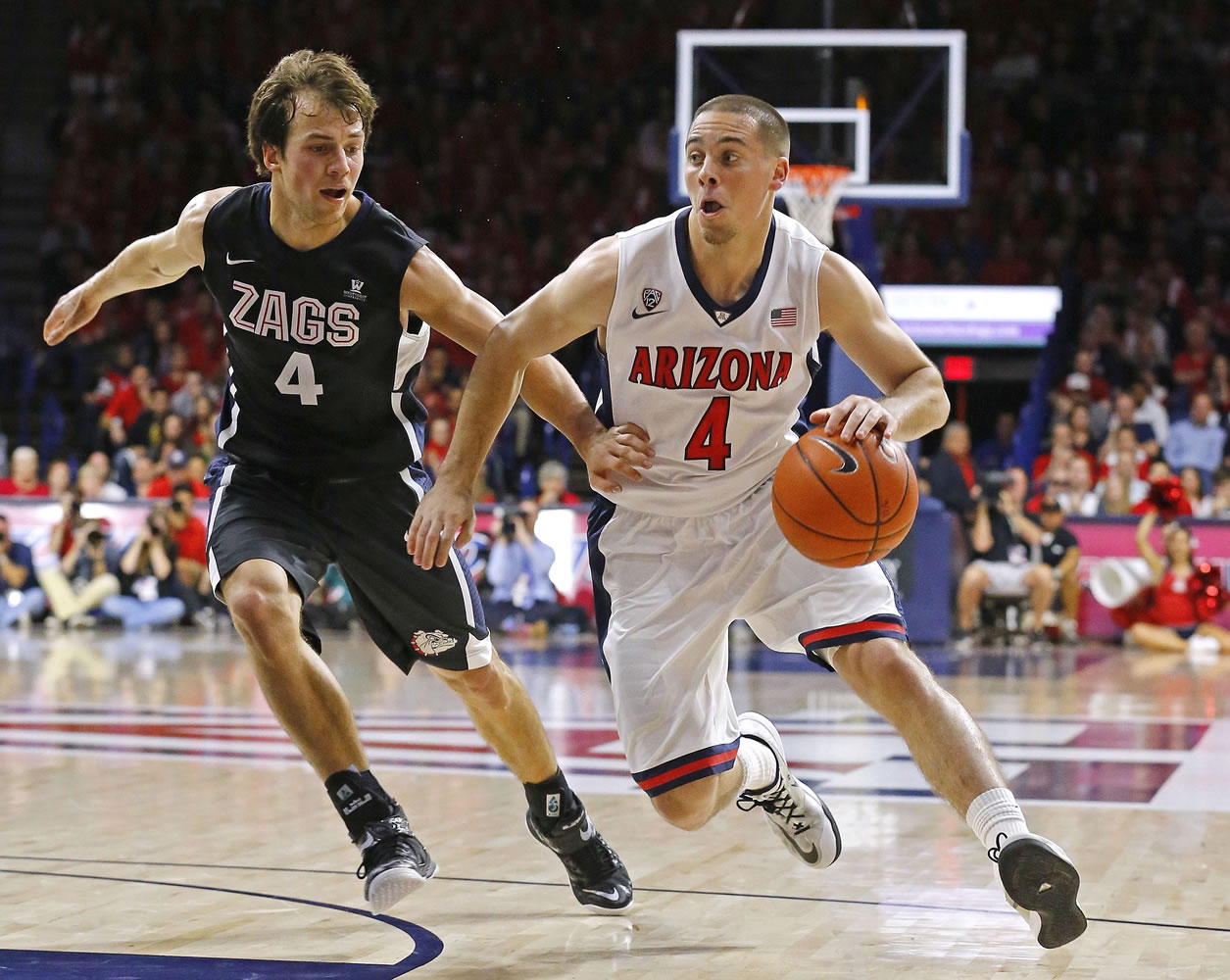 Arizona guard T.J. McConnell, right, drives to the net against Gonzaga guard Kevin Pangos during the first half Saturday, Dec. 6, 2014, in Tucson, Ariz.