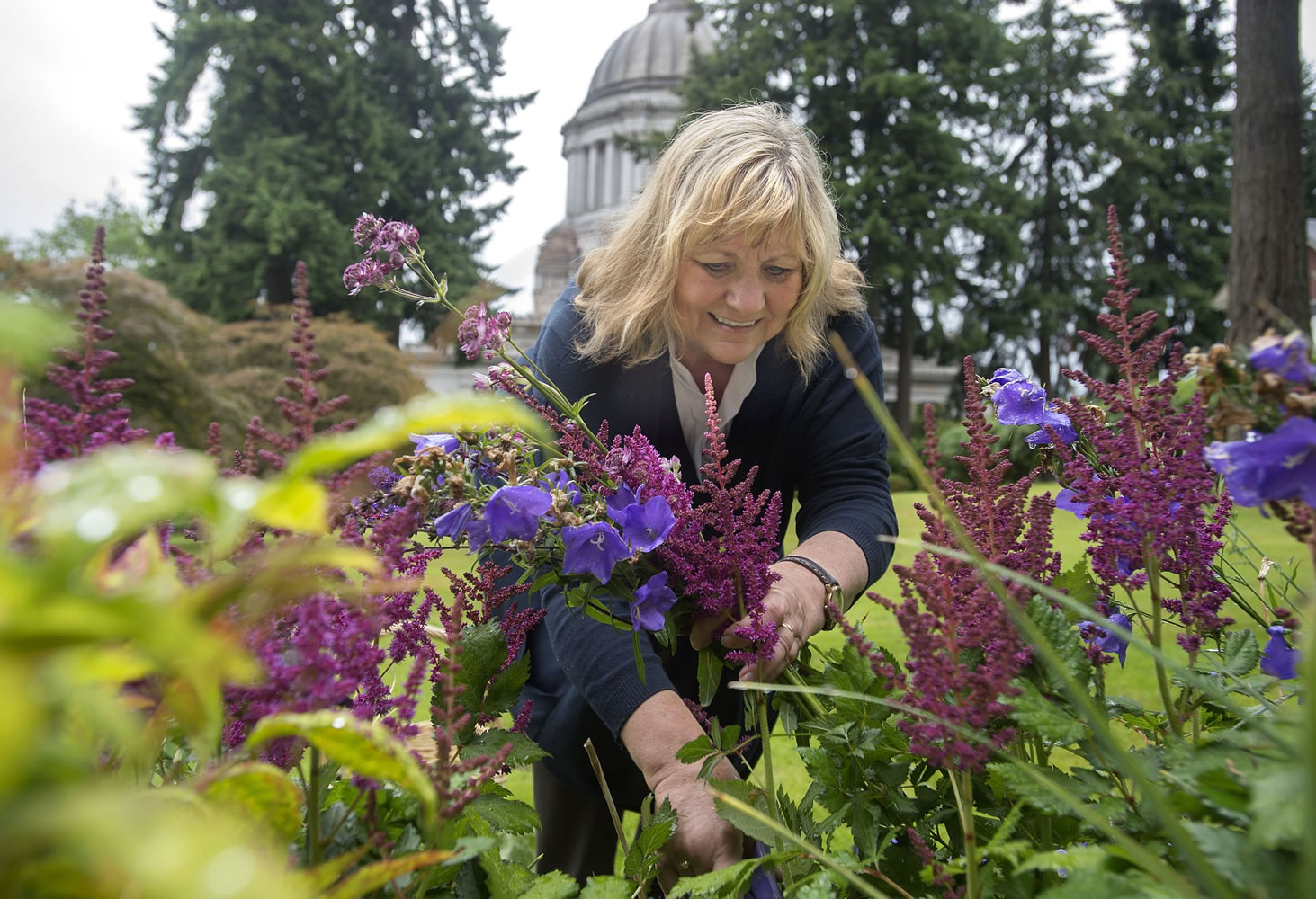 Washington's first lady, Trudi Inslee, works on her flower garden June 27 at the governor's mansion in Olympia.