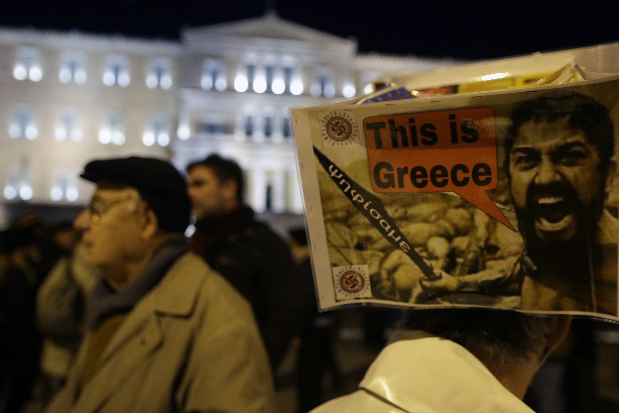 A man wears a placard on his head, made using a photograph from the 2006 American made war fantasy movie '300', and a sword saying &quot;We Voted&quot;, during a rally to support the government's push for a better deal on Greece's debt, outside the Greek government in Athens, on Friday.