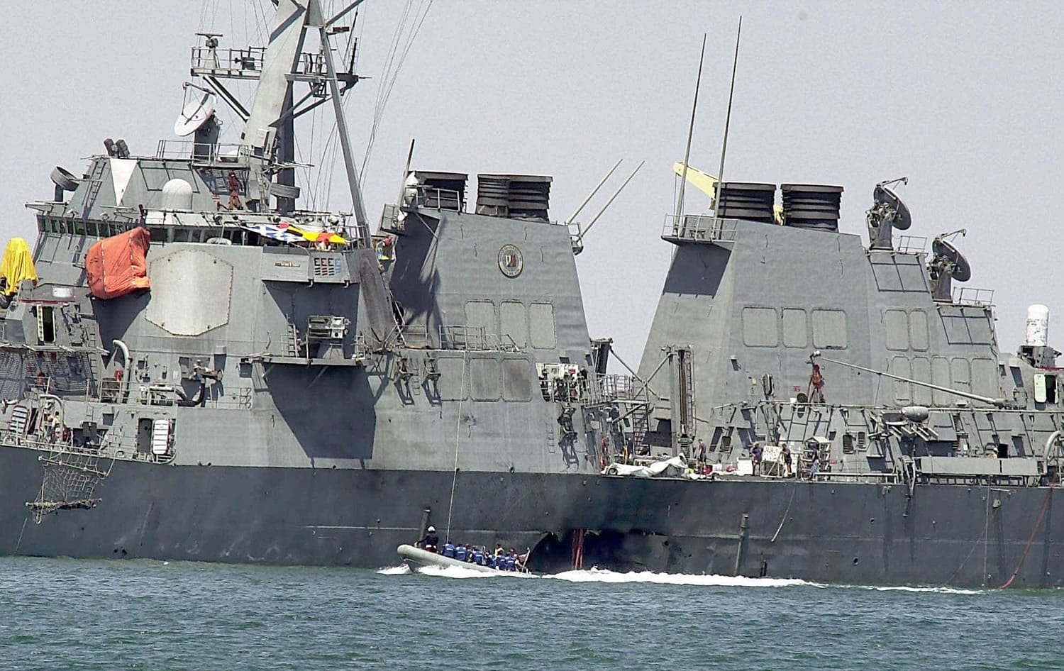 Investigators in a speed boat examine the hull of the USS Cole at the Yemeni port of Aden, after a powerful explosion  ripped a hole in the U.S Navy destroyer in 2000.