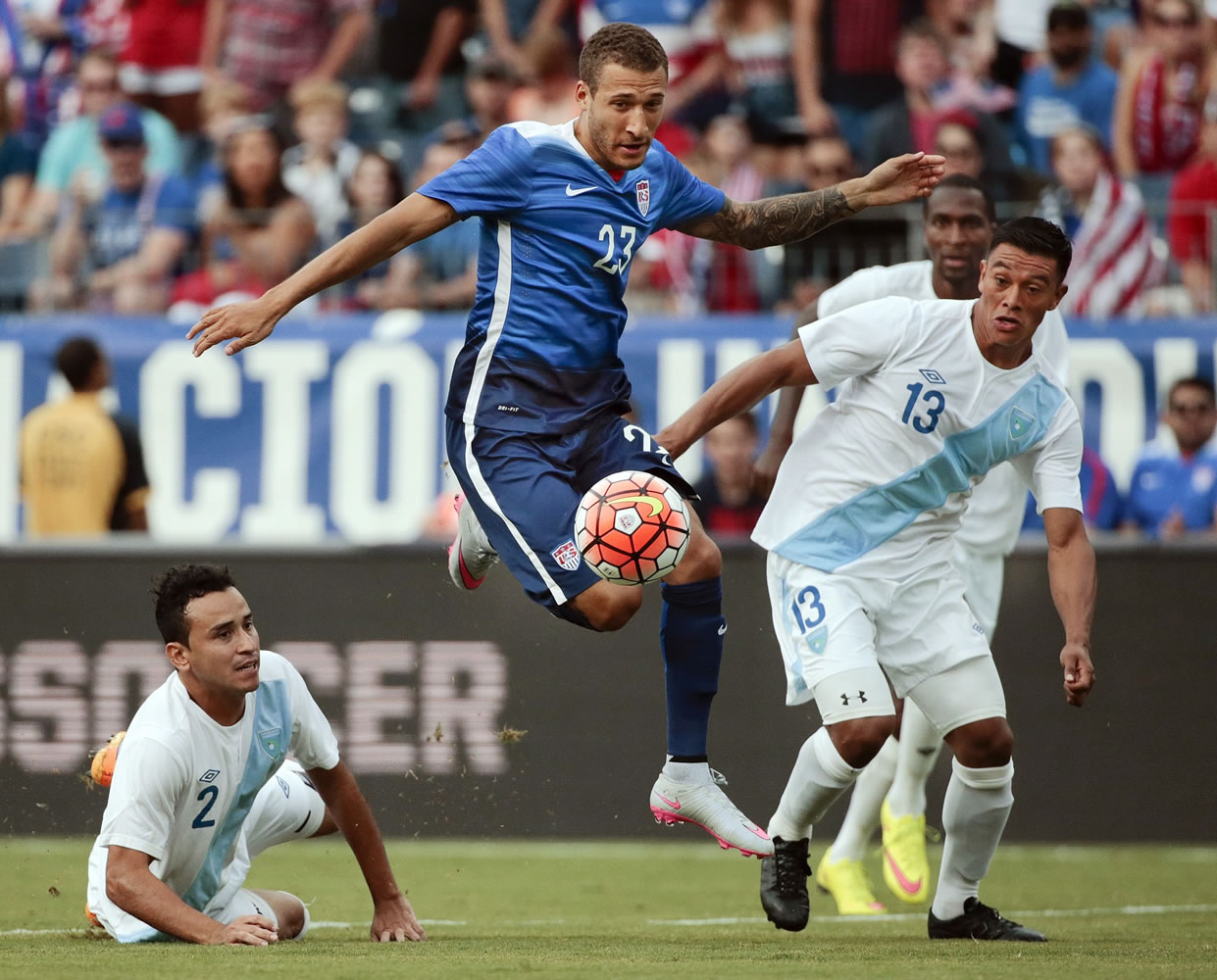 United States' Fabian Johnson midfielder (23) moves the ball between Guatemala defenders Carlos Castrillo (13) and Ruben Morales (2) during the first half of an international friendly soccer match Friday, July 3, 2015, in Nashville, Tenn.