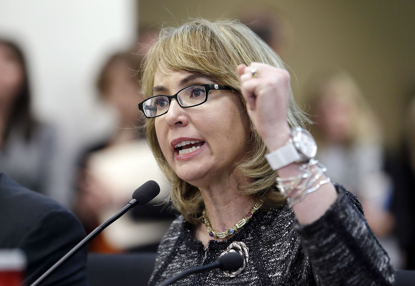 Former Arizona Congresswoman Gabrielle Giffords pumps her fist as she testifies in January  before a Washington state House panel in Olympia.