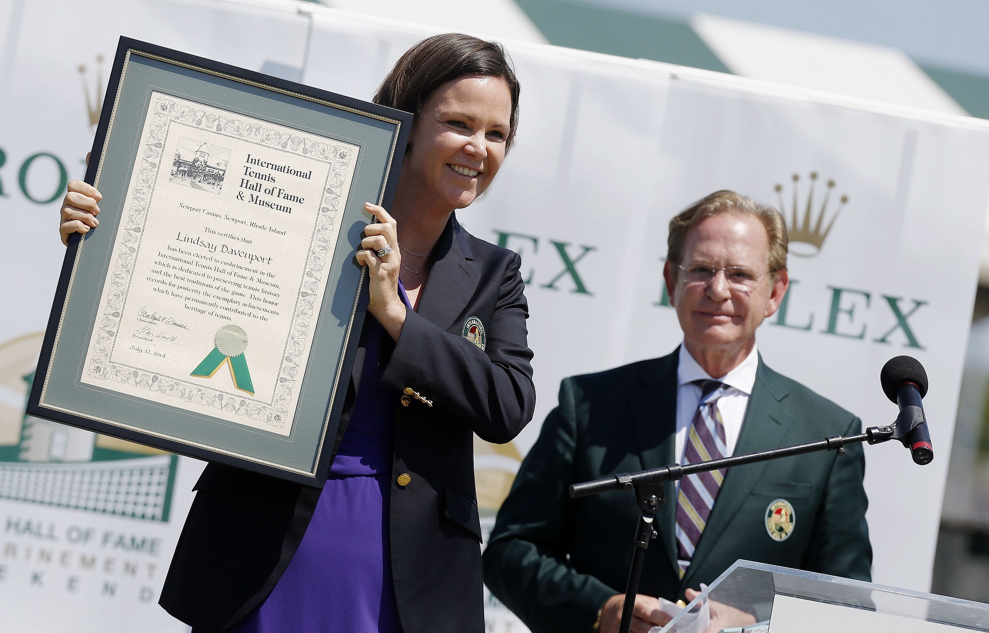 Lindsay Davenport holds her plaque as Christopher Clouser looks on during the induction ceremony at the International Tennis Hall of Fame in Newport, R.I., Saturday, July 12, 2014.