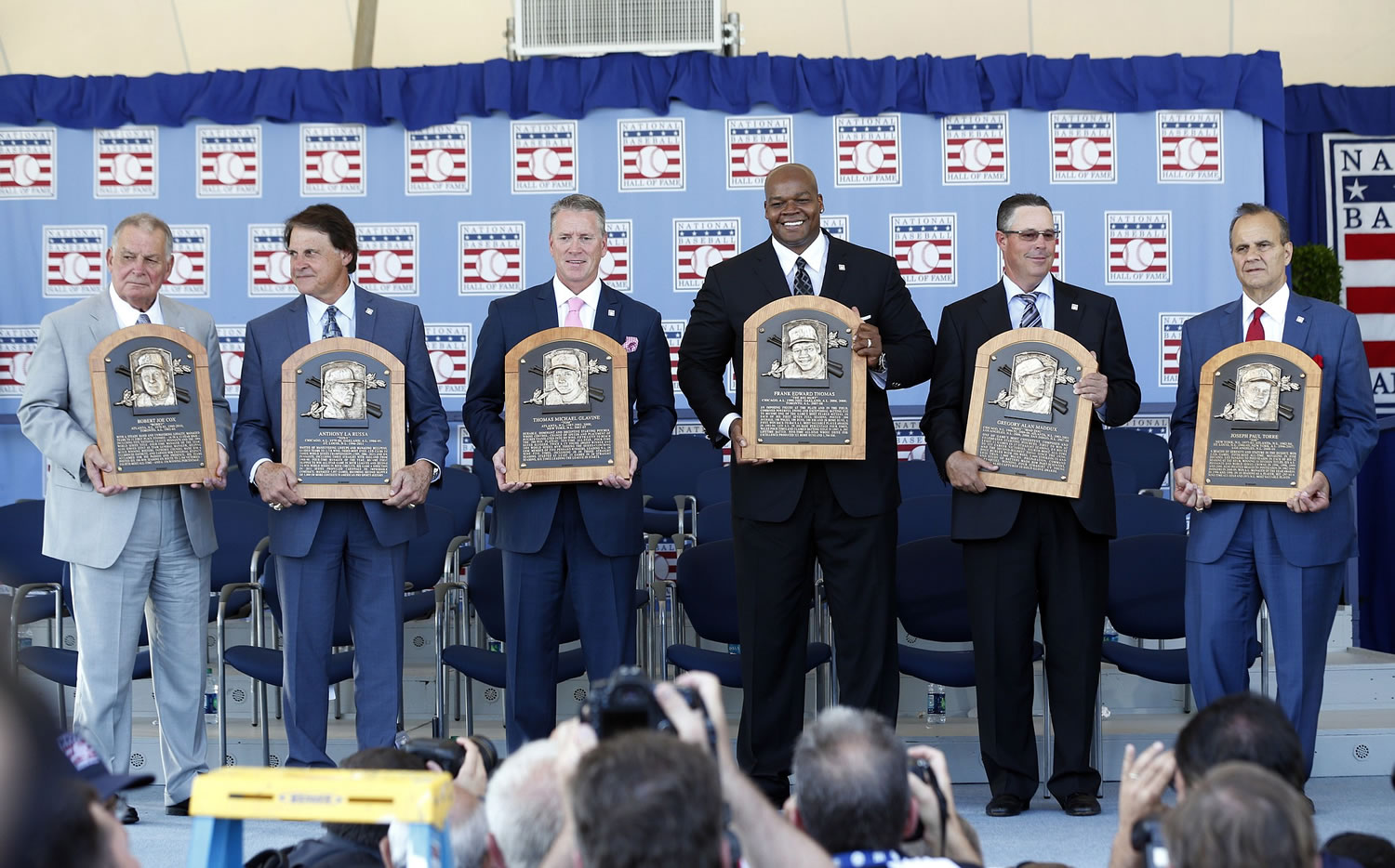 National Baseball Hall of Fame inductees, from left, Bobby Cox, Tony La Russa, Tom Glavine, Frank Thomas, Greg Maddux and Joe Torre hold their plaques after an induction ceremony at the Clark Sports Center on Sunday, July 27, 2014, in Cooperstown, N.Y.