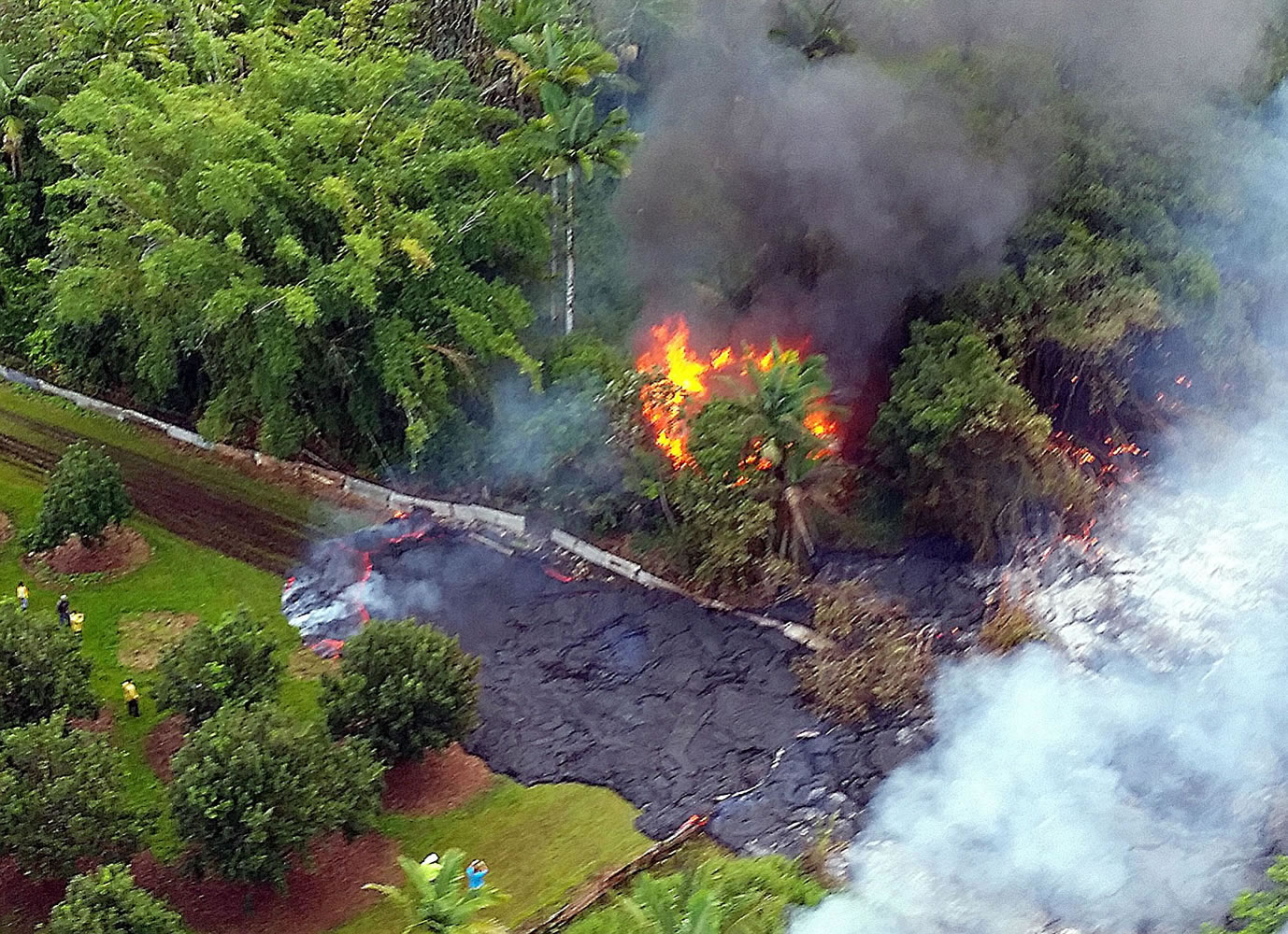 A structure burns as lava flows around it Tuesday near Pahoa on the Big Island of Hawaii.