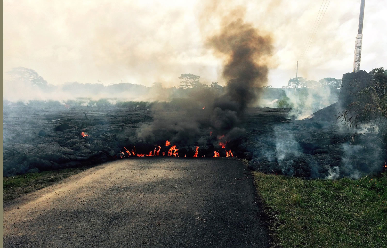 The lava flow from Kilauea Volcano that began June 27 crosses a street near Pahoa on the Big Island of Hawaii.