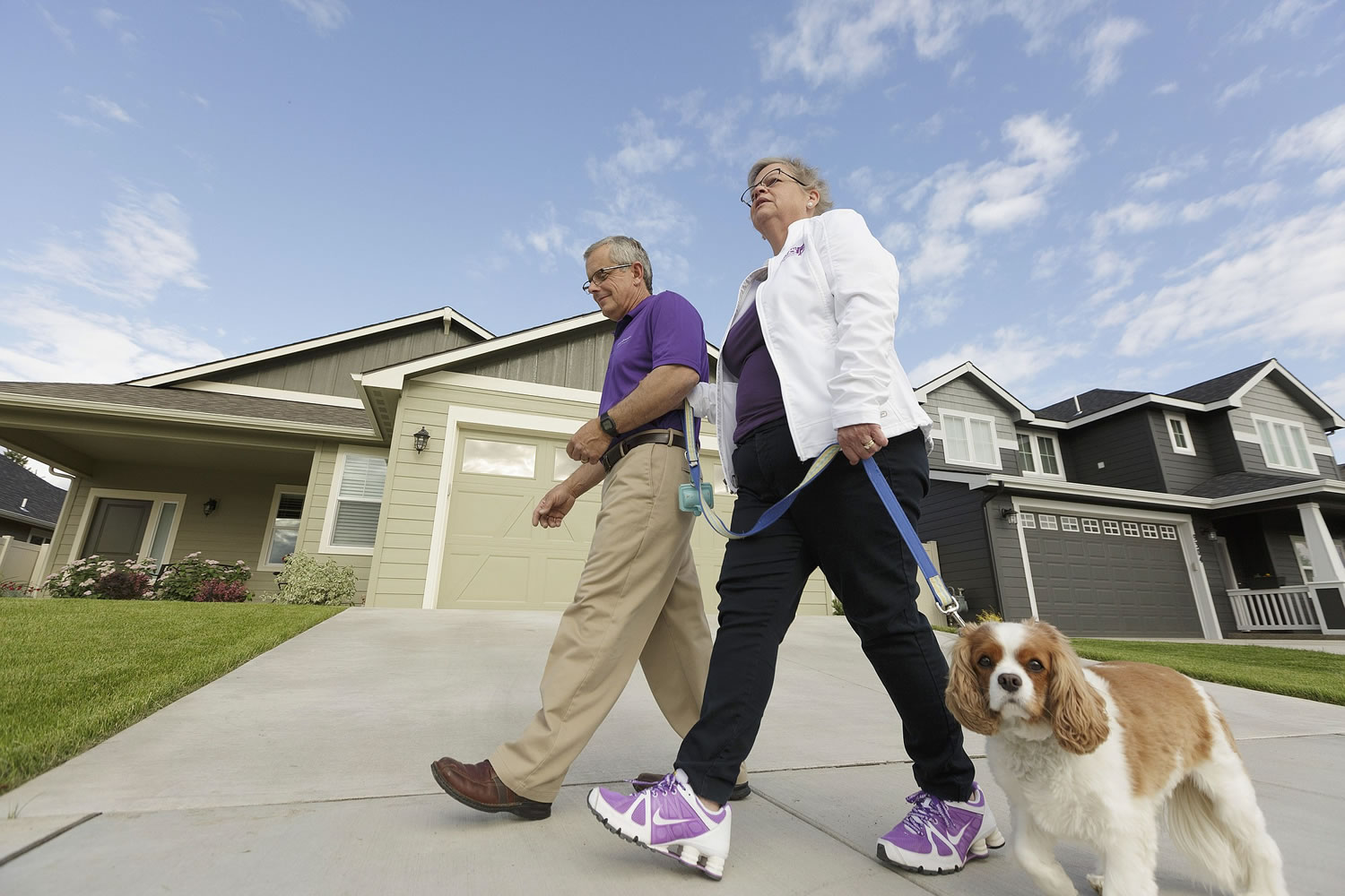 Amy Shives, right, and her husband, George, walk their cavalier King Charles spaniel Chester in their neighborhood June 3 in Spokane. Amy Shives was diagnosed with early onset Alzheimer's disease in 2011 and has since been involved with the Alzheimer's Association.