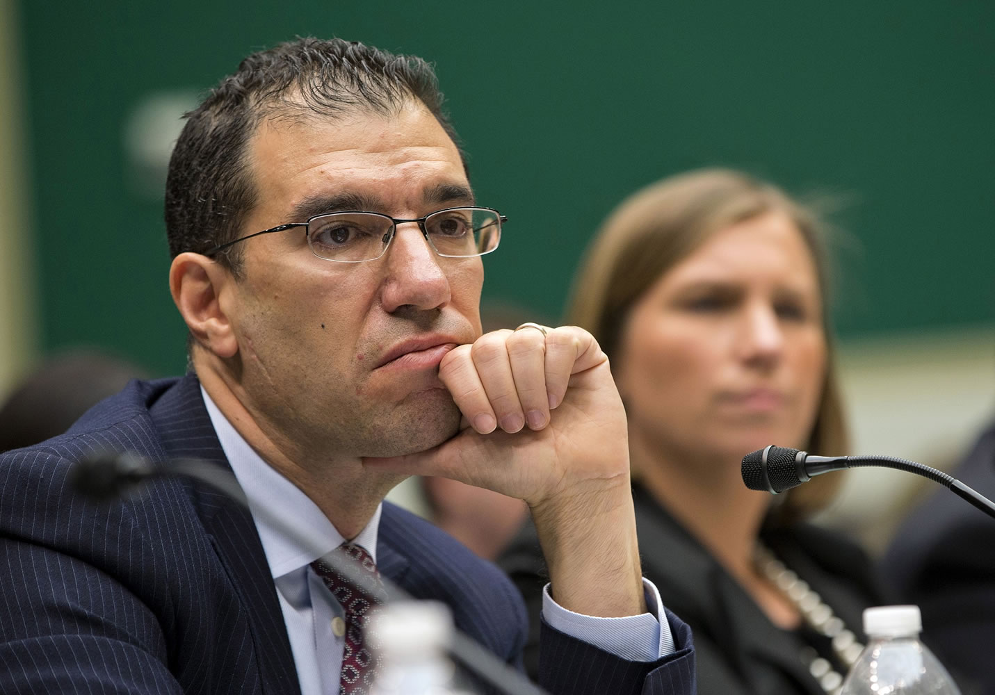 Andrew Slavitt, group executive vice president for Optum/QSSI, left, and Lynn Spellecy, corporate counsel for Equifax Workforce Solutions, listen to questioning during a House Energy and Commerce Committee hearing with contractors that built the federal government's health care websites in Washington.