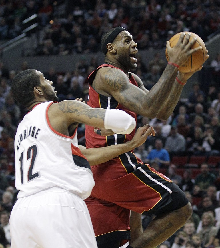 Miami Heat's LeBron James drives to the basket as Portland Trail Blazers' LaMarcus Aldridge (12) defends in the first quarter of Sunday's NBA game at the Rose Garden.