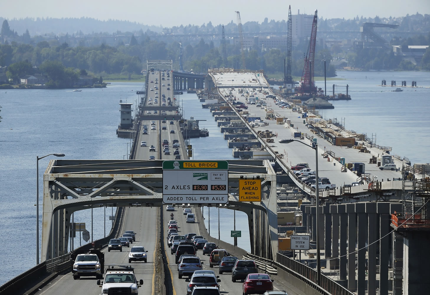 Traffic is shown on the State Route 520 floating bridge at left in Medina while construction continues at right on a new floating bridge to replace it.