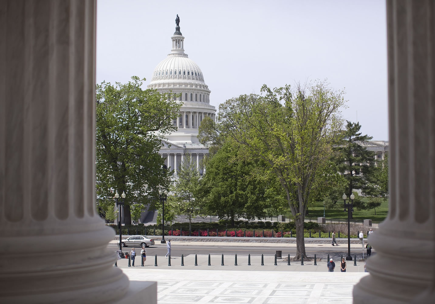 The U.S. Capitol building is seen through the columns on the steps of the Supreme Court in Washington in May. The House approved a bill that would temporarily patch over a multibillion-dollar pothole in federal highway and transit programs while ducking the issue of how to put the programs on sound financial footing for the long term.