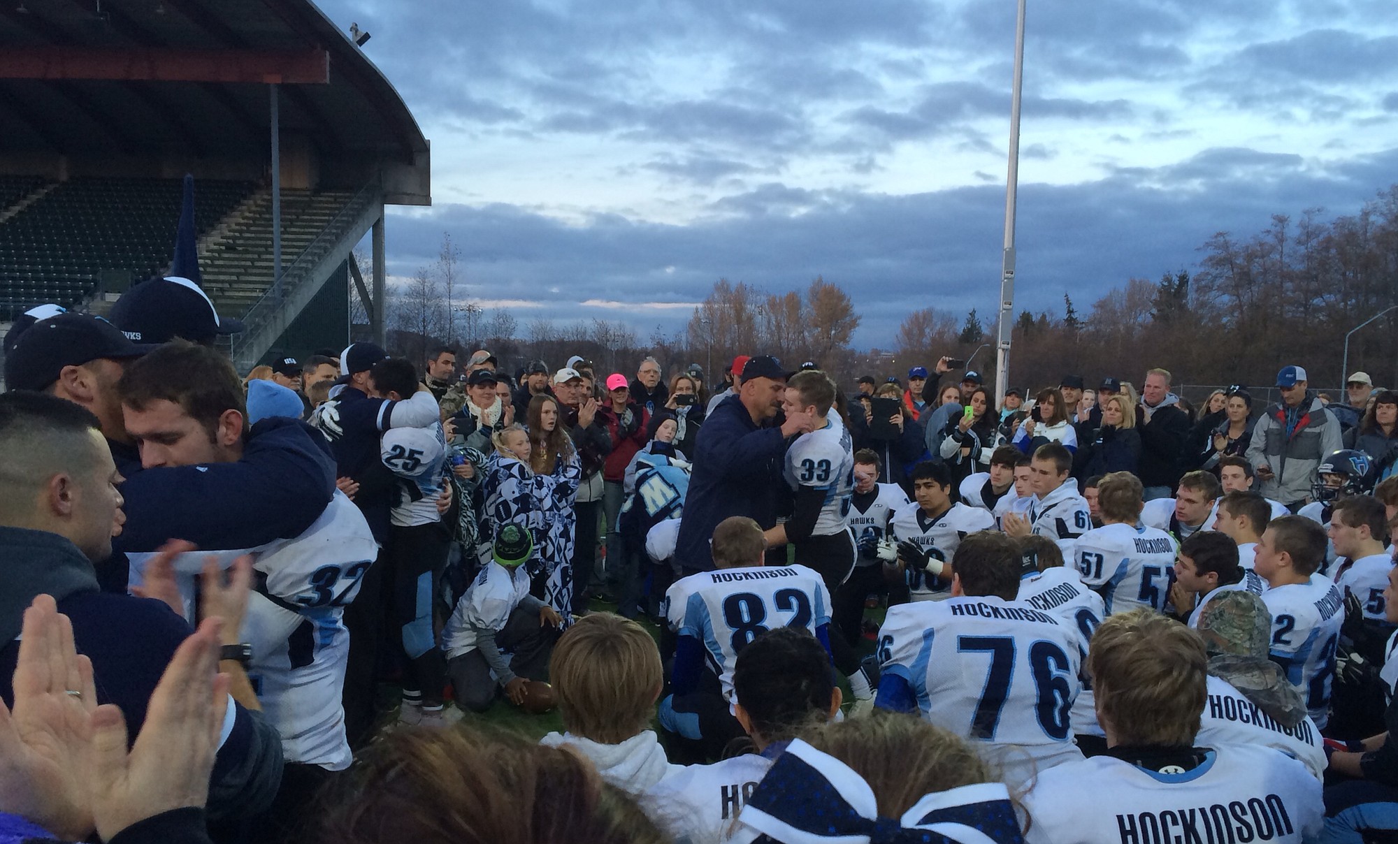 Hockinson's Austen Johnson (33) is hugged by coach Rick Steele following the Hawks' 52-28 season-ending loss to Lynden on Saturday at Civic Stadium in Bellingham.