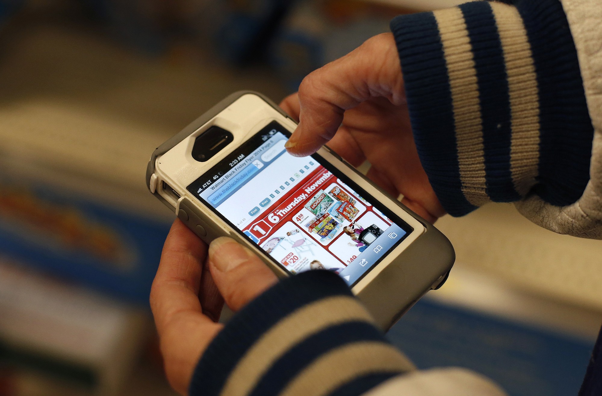 A Target shopper uses her iPhone to compare prices at Wal-Mart while shopping after midnight in South Portland, Maine.