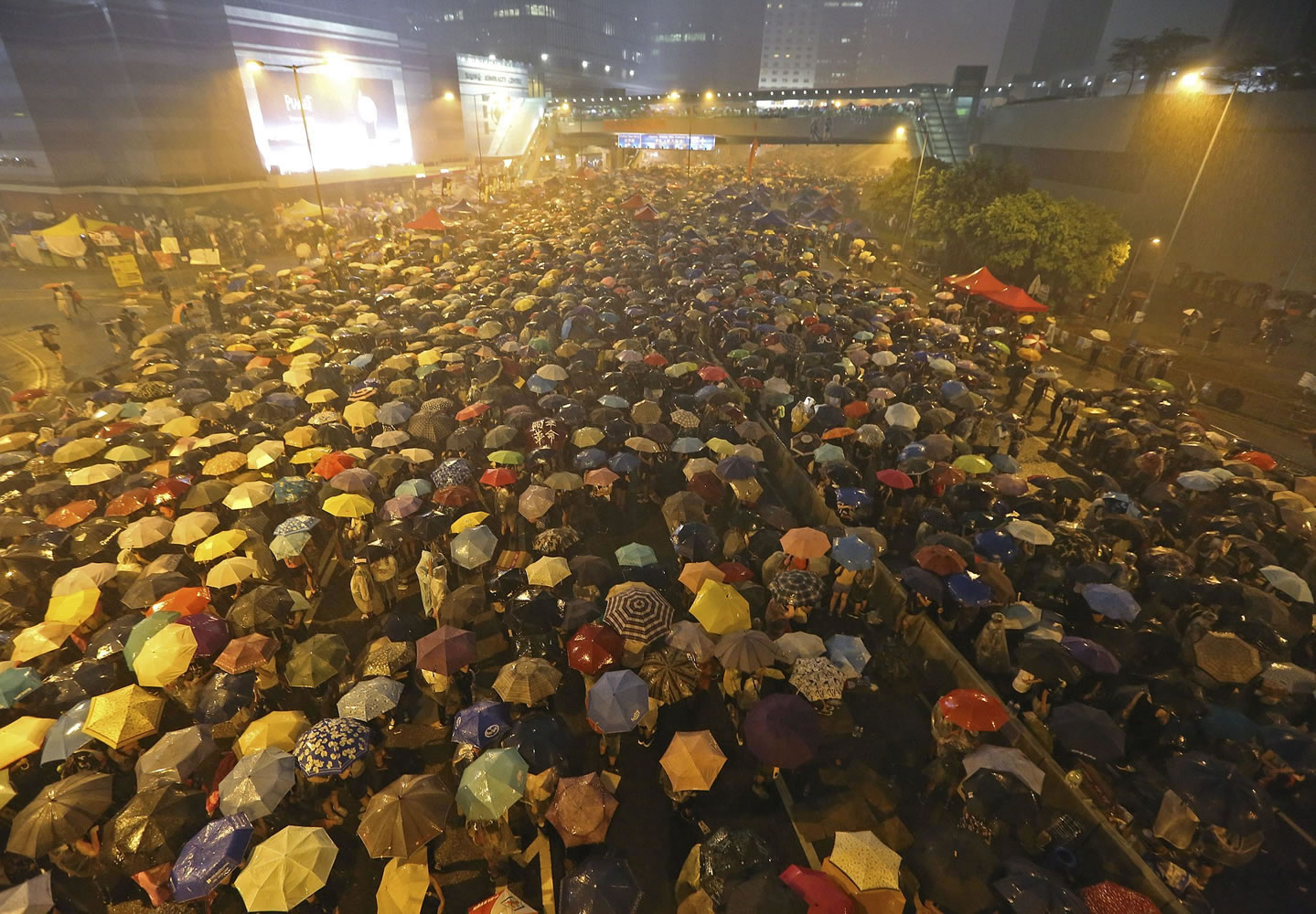 Pro-democracy protesters hold umbrellas under heavy rain in a main street near the government headquarters in Hong Kong late Tuesday.