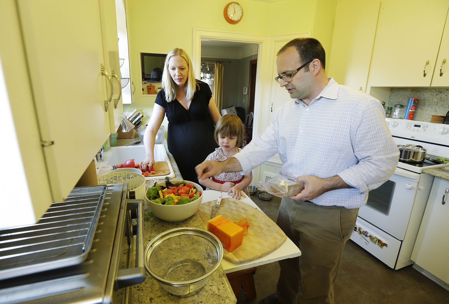 Ryan Carson, right, cooks dinner with his wife, Jenny Roraback-Carson, left, and their daughter Clara, 3, at their home in Seattle.