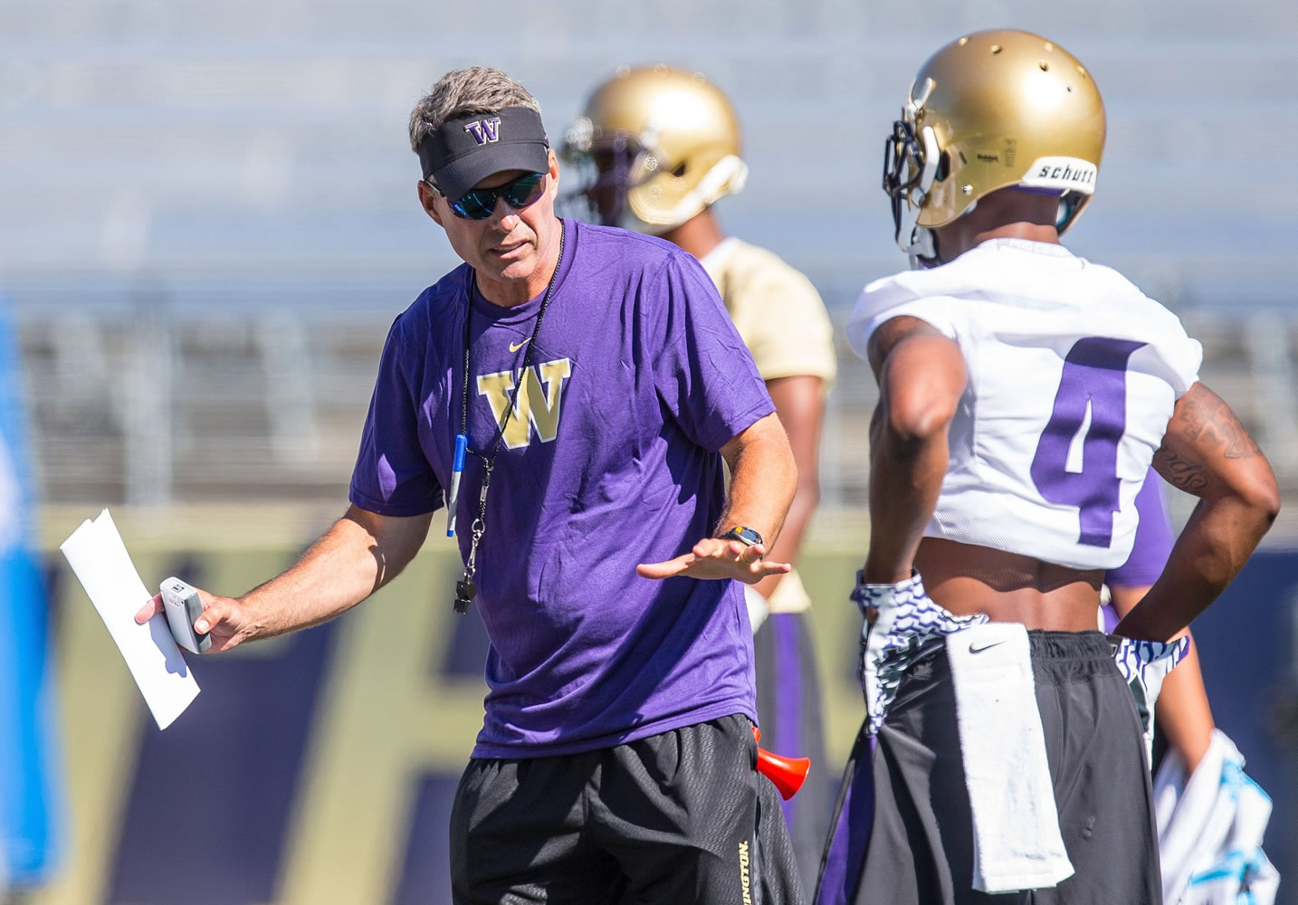 University of Washington head coach Chris Petersen coaches wide receiver Jaydon Mickens at Husky Stadium in a practice for veteran players on Monday, Aug.