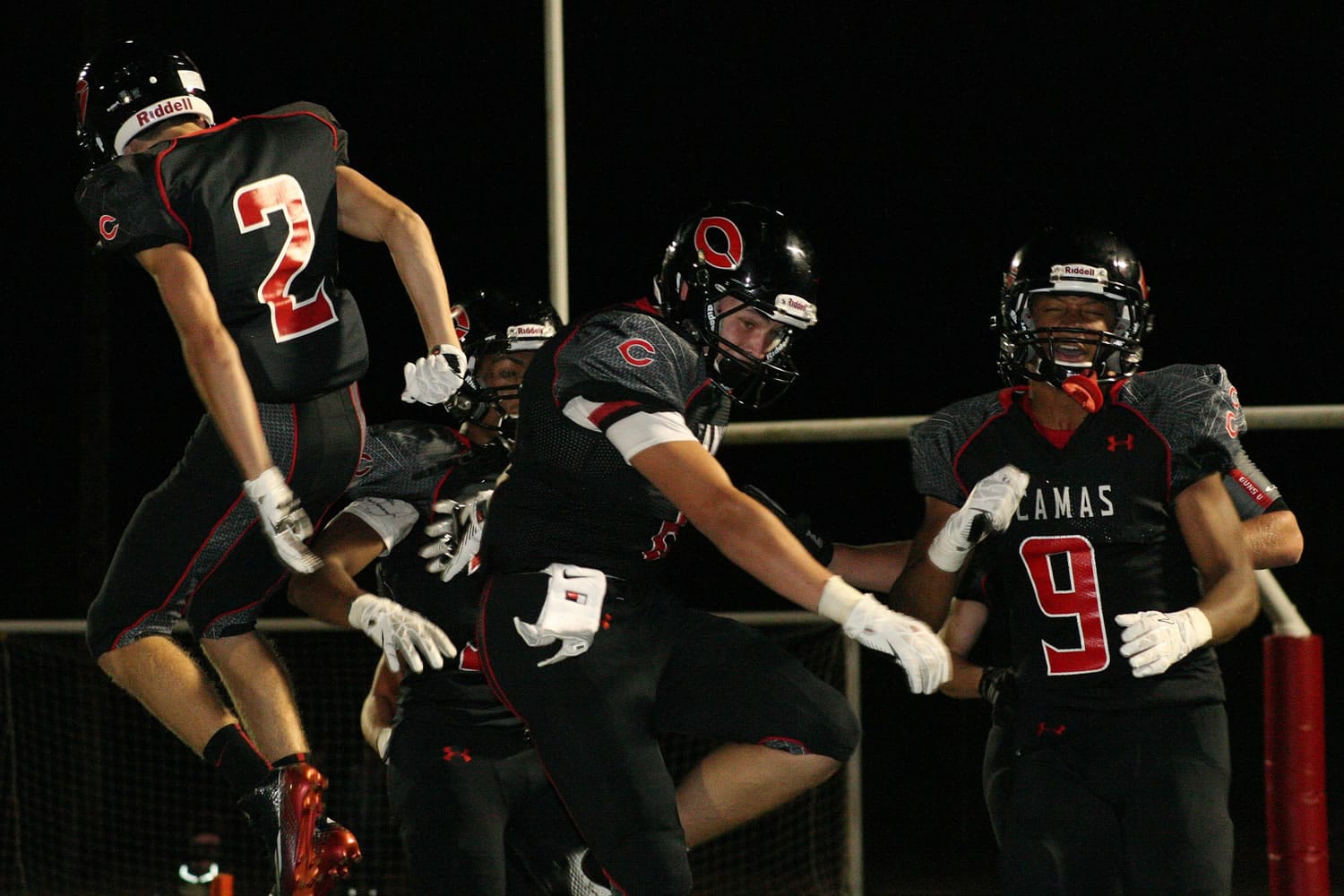 Dane Santos celebrates with his teammates after returning an interception for a 45-yard touchdown.