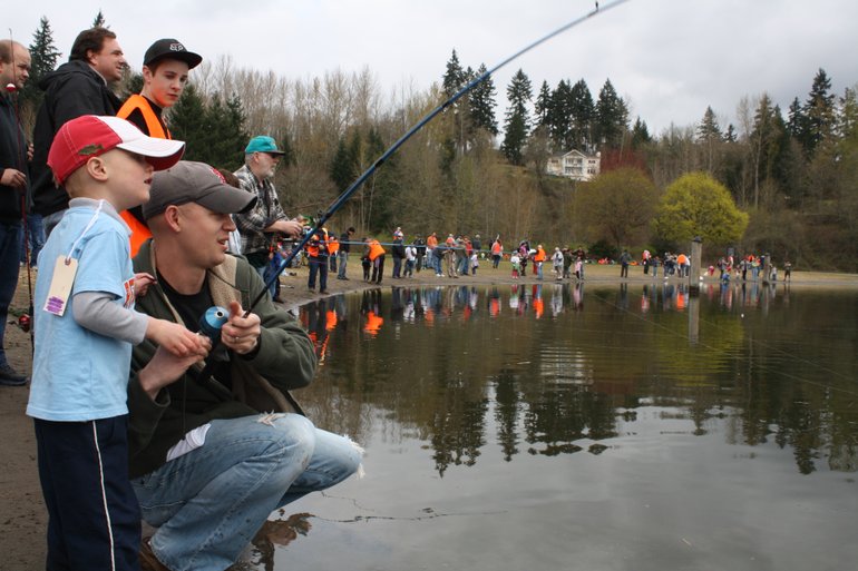 Cayden Crabtree, 5, fishes next to his father, Chase, along with hundreds of other children in the 10 a.m.