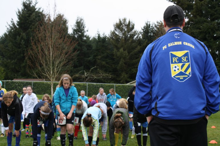 Salmon Creek Soccer Club coach Paul Madden looks on as U-11 tryouts stretch before taking the fields for drills and exhibition play to see who will make this spring's select and premier teams.