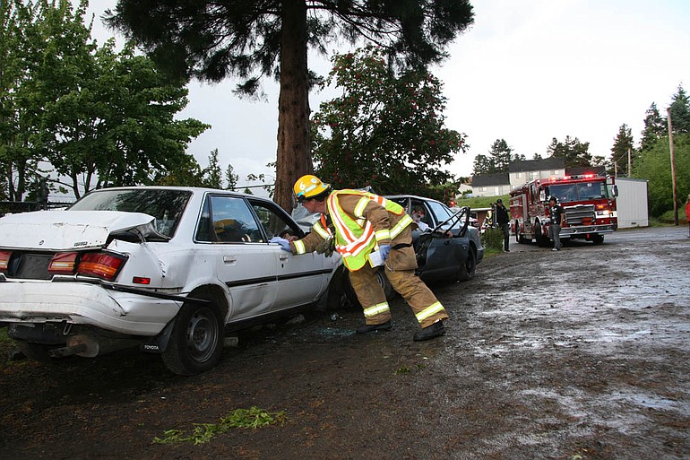 Firefighters work to reach students who played victims in a mock DUI crash at Columbia River High School Thursday morning.