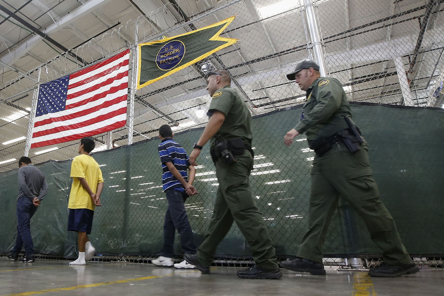 Young detainees are escorted to an area to make phone calls as hundreds of mostly Central American immigrant children are being processed and held at the U.S.