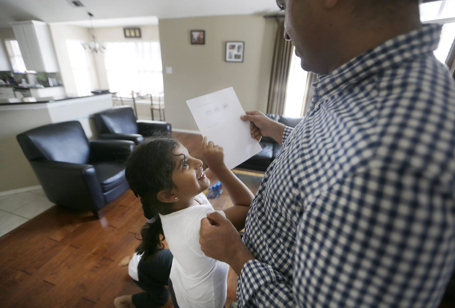 Sita Jaganath, 7, left, shows her father Siddharth Jaganath a math problem she worked out at their home Friday  in Plano, Texas.  U.S. Census Bureau research shows immigrants from China and India, many with student or work visas, have overtaken Mexicans as the largest groups coming into the U.S. Jaganath is an example of the new trend in immigration. He came to the U.S. to earn his master's degree at Southern Methodist University. Instead of returning to India, he built a new life in the U.S.